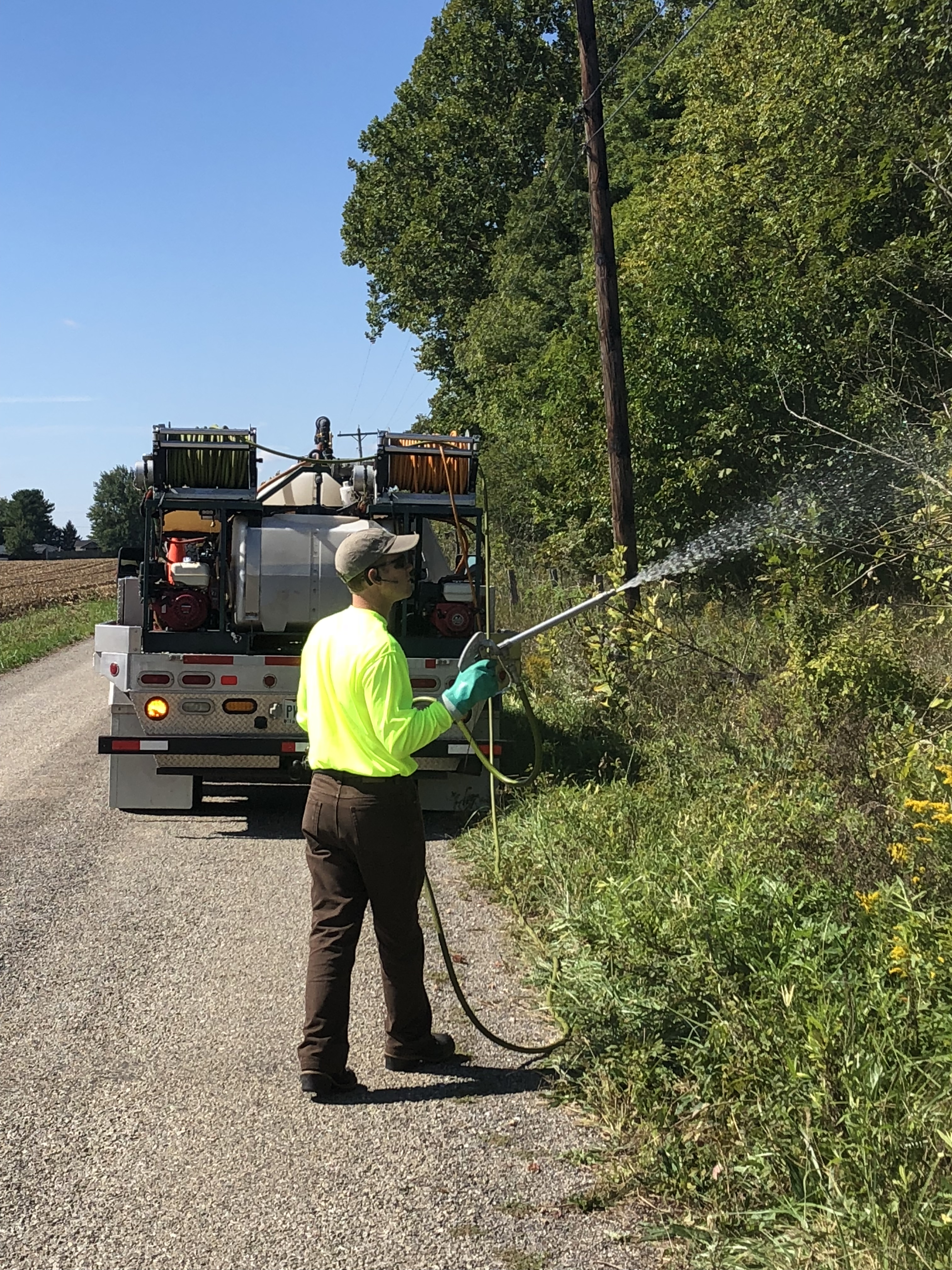 Guy applying herbicide on roadside in Troy